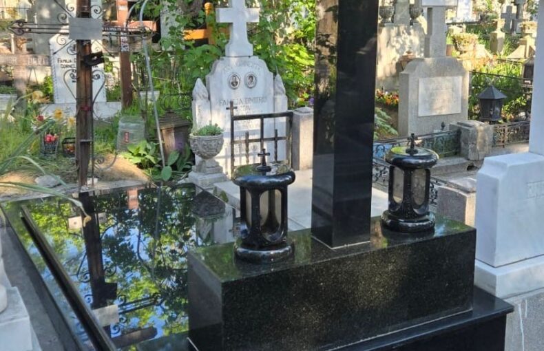 Monument funerar din granit negru montat intr-un cimitir de stat