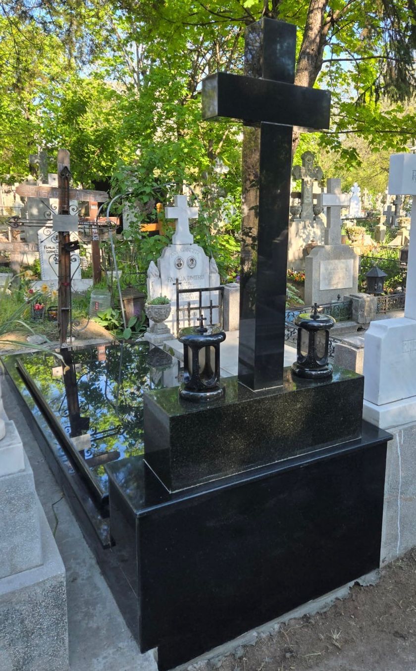 Monument funerar din granit negru montat intr-un cimitir de stat